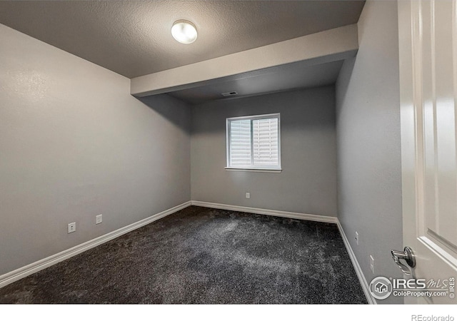 13598 Horseshoe Cir, Mead, CO 80542 - unfurnished room with dark colored carpet, baseboards, and a textured ceiling