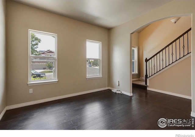 13598 Horseshoe Cir, Mead, CO 80542 - spare room featuring plenty of natural light, stairs, and arched walkways