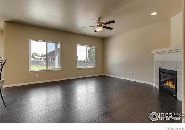 13598 Horseshoe Cir, Mead, CO 80542 - unfurnished living room with ceiling fan, dark wood-type flooring, a tile fireplace, baseboards, and recessed lighting