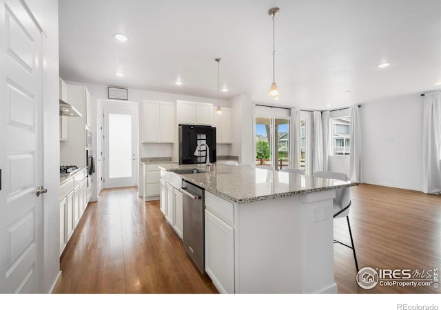 2031 Moon Rise Dr, Windsor, CO 80550 - kitchen with appliances with stainless steel finishes, a sink, wood finished floors, white cabinetry, and recessed lighting
