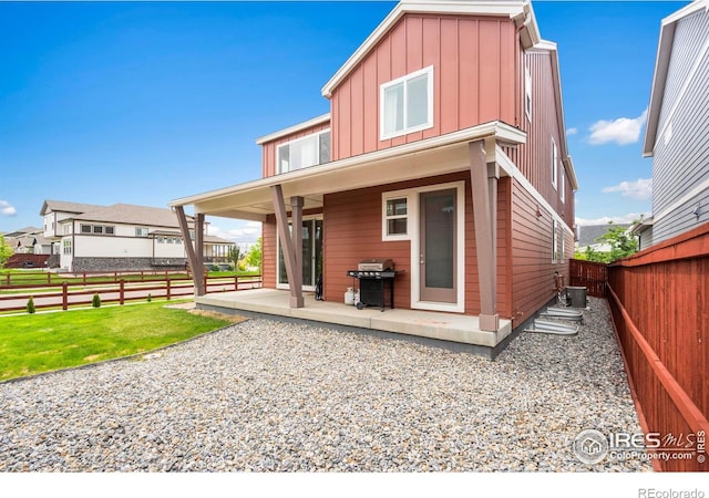 2031 Moon Rise Dr, Windsor, CO 80550 - rear view of house with board and batten siding, a patio, and central AC
