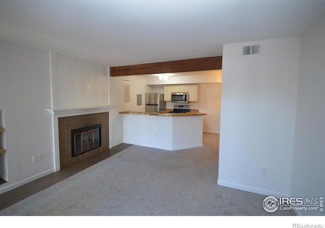 30 S Boulder Cir Unit 30182102, Boulder, CO 80303 - unfurnished living room featuring a tile fireplace, carpet floors, beamed ceiling, and baseboards
