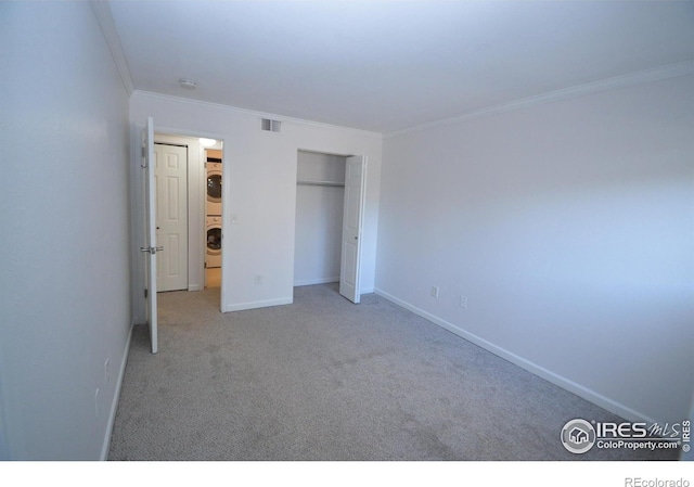 30 S Boulder Cir Unit 30182102, Boulder, CO 80303 - unfurnished bedroom featuring stacked washing machine and dryer, crown molding, carpet floors, a closet, and baseboards