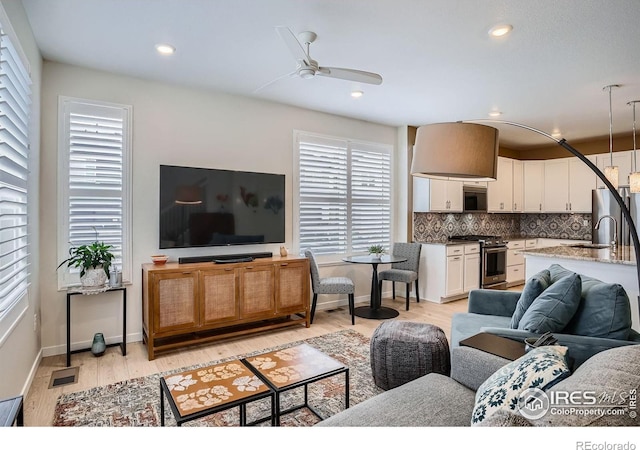 14553 W 91st Dr Unit A, Arvada, CO 80005 - living room featuring ceiling fan, light wood-style floors, baseboards, and recessed lighting