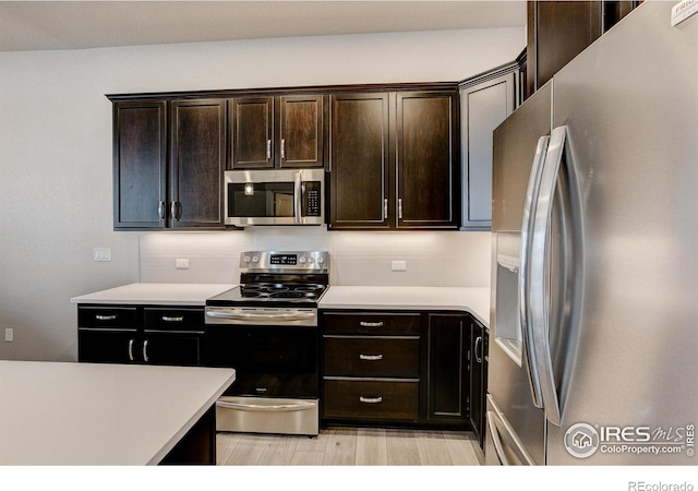 4173 Trapper Lake Dr, Loveland, CO 80538 - kitchen featuring stainless steel appliances, light countertops, dark brown cabinetry, and light wood finished floors