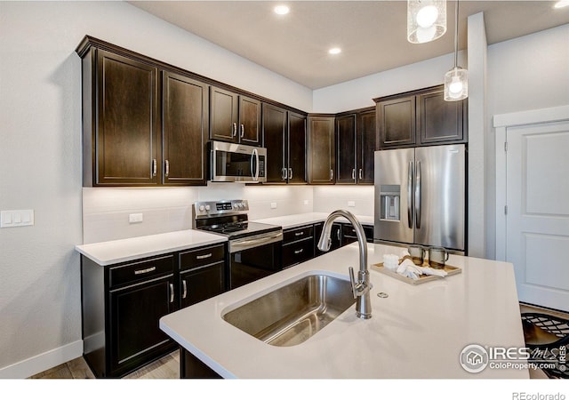 4173 Trapper Lake Dr, Loveland, CO 80538 - kitchen featuring stainless steel appliances, a sink, light countertops, dark brown cabinets, and baseboards
