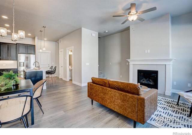4173 Trapper Lake Dr, Loveland, CO 80538 - living room featuring light wood-type flooring, a ceiling fan, recessed lighting, baseboards, and a chandelier