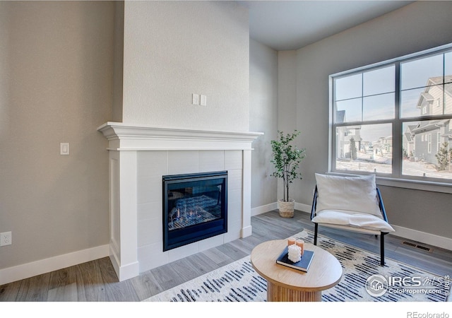 4173 Trapper Lake Dr, Loveland, CO 80538 - living room with a tile fireplace, wood finished floors, and baseboards