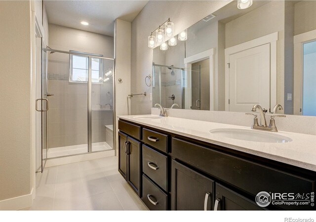 4173 Trapper Lake Dr, Loveland, CO 80538 - full bathroom featuring a stall shower, double vanity, tile patterned floors, and baseboards