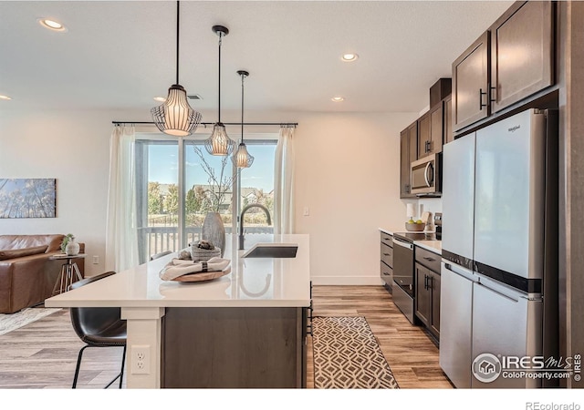 2446 W 167th Ln, Broomfield, CO 80023 - kitchen featuring appliances with stainless steel finishes, a sink, light countertops, recessed lighting, and light wood-style floors