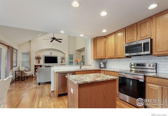 5603 Pierson Mountain Ave, Longmont, CO 80503 - kitchen with stainless steel appliances, a sink, open floor plan, light stone countertops, and lofted ceiling