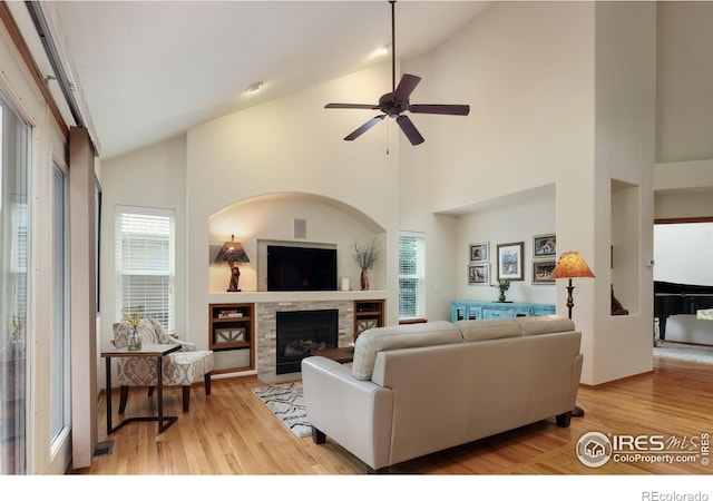 5603 Pierson Mountain Ave, Longmont, CO 80503 - living room with plenty of natural light, a fireplace, ceiling fan, light wood-type flooring, and high vaulted ceiling