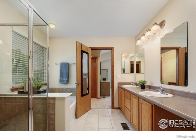 5603 Pierson Mountain Ave, Longmont, CO 80503 - full bathroom with marble finish flooring, double vanity, a garden tub, and an enclosed shower