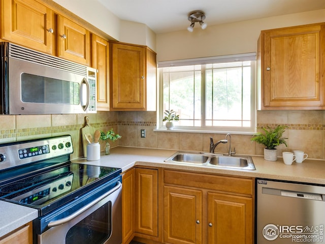 4800 Osage Dr Unit 12B, Boulder, CO 80303 - kitchen with stainless steel appliances, a sink, light countertops, backsplash, and brown cabinets