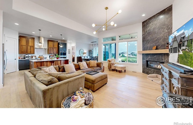 2790 Heron Lakes Pkwy, Berthoud, CO 80513 - living area with light wood-style floors, a chandelier, recessed lighting, and a fireplace