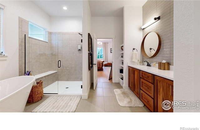 2790 Heron Lakes Pkwy, Berthoud, CO 80513 - bathroom with vanity, tile patterned flooring, a freestanding tub, and a stall shower