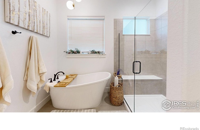 2790 Heron Lakes Pkwy, Berthoud, CO 80513 - bathroom featuring a shower stall, a freestanding bath, and baseboards