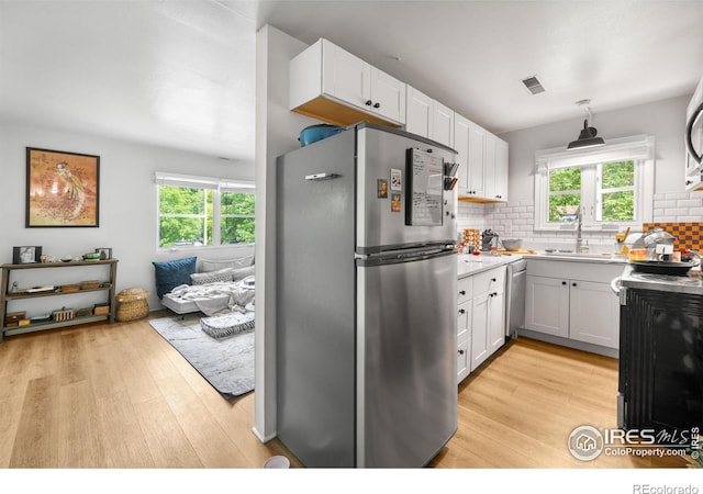 508 Pearl St, Boulder, CO 80302 - kitchen with stainless steel appliances, light wood finished floors, backsplash, open floor plan, and light countertops