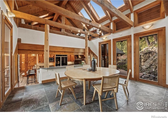 172 Tall Pine Ln, Boulder, CO 80302 - dining space featuring stone tile flooring, high vaulted ceiling, a chandelier, and beamed ceiling