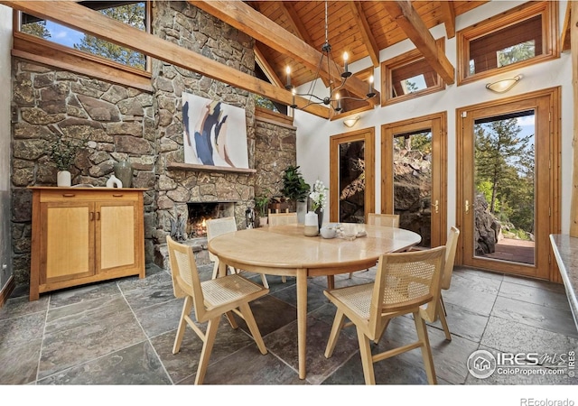 172 Tall Pine Ln, Boulder, CO 80302 - dining space with stone tile flooring, wooden ceiling with exposed beams, high vaulted ceiling, a fireplace, and a chandelier