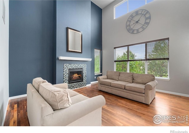 17805 Coral Burst St, Parker, CO 80134 - living area with baseboards, wood finished floors, a fireplace, and a high ceiling