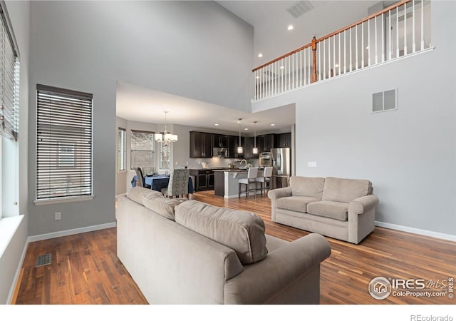 17805 Coral Burst St, Parker, CO 80134 - living area with a high ceiling, a chandelier, dark wood-style floors, baseboards, and recessed lighting