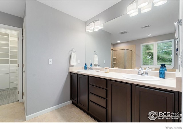 17805 Coral Burst St, Parker, CO 80134 - full bathroom featuring tile patterned flooring, double vanity, a shower stall, a spacious closet, and baseboards
