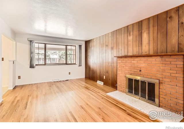 1025 Edinboro Dr, Boulder, CO 80305 - unfurnished living room featuring wood finished floors, a fireplace, and wooden walls