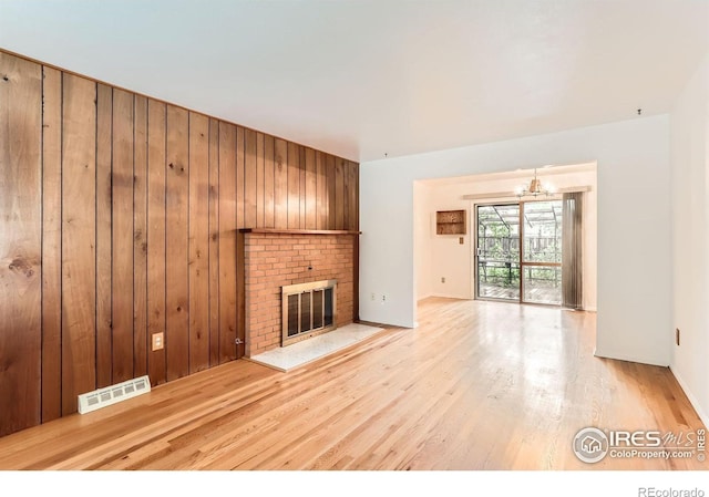 1025 Edinboro Dr, Boulder, CO 80305 - unfurnished living room with a fireplace, a chandelier, light wood finished floors, and wooden walls