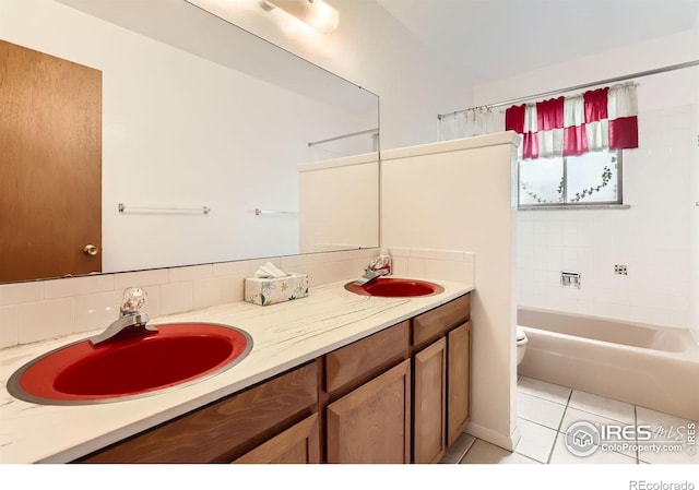 1025 Edinboro Dr, Boulder, CO 80305 - full bathroom with toilet, double vanity, tile patterned floors, backsplash, and shower / bathtub combination