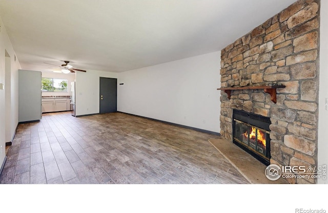3526 S Depew St Unit 102, Lakewood, CO 80235 - unfurnished living room featuring a fireplace, ceiling fan, wood finished floors, and baseboards