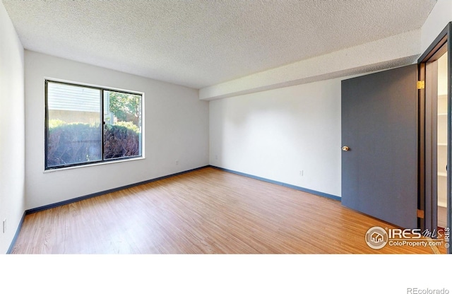 3526 S Depew St Unit 102, Lakewood, CO 80235 - unfurnished room featuring a textured ceiling, wood finished floors, and baseboards