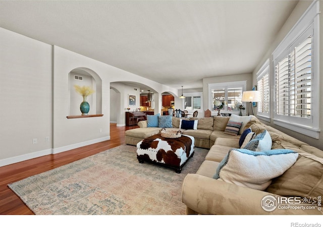 2005 Calico Ct, Longmont, CO 80503 - living room featuring arched walkways, wood finished floors, and baseboards