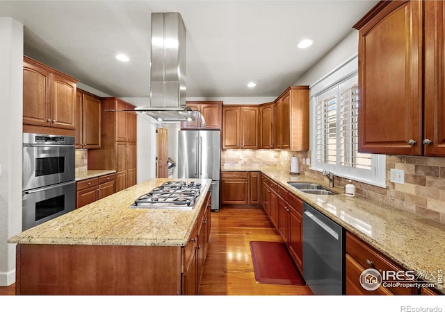 2005 Calico Ct, Longmont, CO 80503 - kitchen featuring appliances with stainless steel finishes, a sink, light wood-style flooring, island exhaust hood, and light stone counters