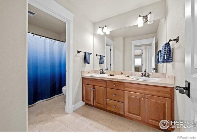 2005 Calico Ct, Longmont, CO 80503 - full bath featuring double vanity, toilet, and tile patterned flooring