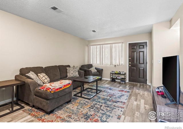 2840 W 21st St Unit 14, Greeley, CO 80634 - living room featuring wood finished floors, baseboards, and a textured ceiling