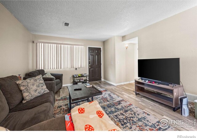2840 W 21st St Unit 14, Greeley, CO 80634 - living room with wood finished floors, a textured ceiling, and baseboards