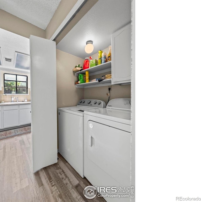 2840 W 21st St Unit 14, Greeley, CO 80634 - laundry area with washing machine and clothes dryer, light wood-style flooring, and a textured ceiling