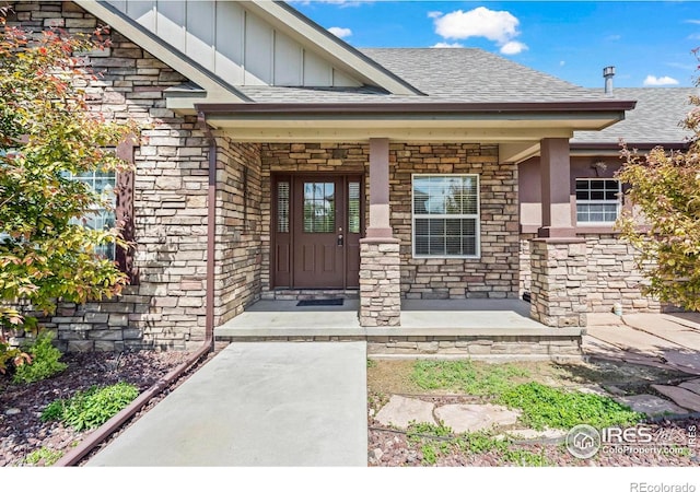 29 Pioneer Pl, Eaton, CO 80615 - doorway to property with stone siding, board and batten siding, a shingled roof, and covered porch
