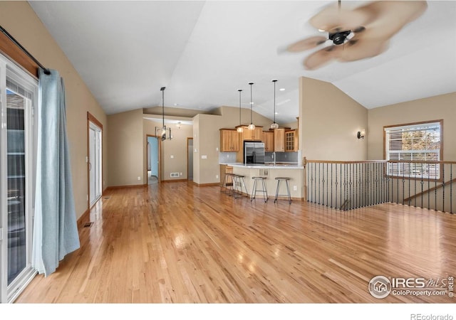 29 Pioneer Pl, Eaton, CO 80615 - living area featuring light wood-type flooring, vaulted ceiling, a ceiling fan, a chandelier, and baseboards