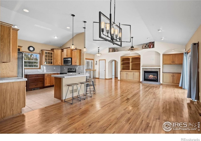 29 Pioneer Pl, Eaton, CO 80615 - kitchen with appliances with stainless steel finishes, a breakfast bar, open floor plan, light countertops, and high vaulted ceiling