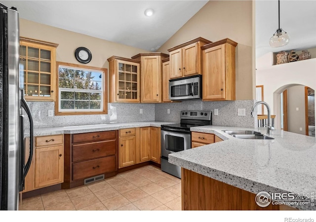 29 Pioneer Pl, Eaton, CO 80615 - kitchen featuring stainless steel appliances, a sink, arched walkways, decorative backsplash, and light tile patterned flooring