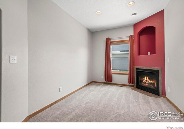 29 Pioneer Pl, Eaton, CO 80615 - unfurnished living room with carpet, baseboards, a fireplace with flush hearth, and recessed lighting