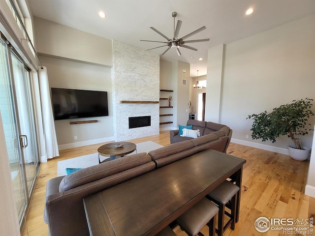 4236 Carroway Seed Ct, Johnstown, CO 80534 - living room with ceiling fan, a stone fireplace, recessed lighting, light wood-style floors, and baseboards