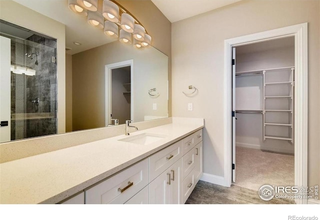 4236 Carroway Seed Ct, Johnstown, CO 80534 - bathroom featuring a spacious closet, vanity, a stall shower, and baseboards