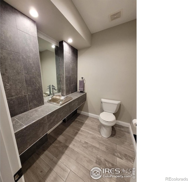 4236 Carroway Seed Ct, Johnstown, CO 80534 - bathroom featuring toilet, baseboards, a sink, recessed lighting, and wood finished floors