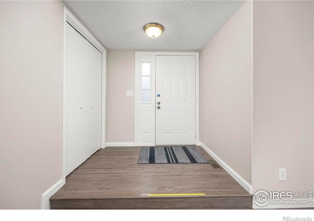 8423 Everett Way Unit A, Arvada, CO 80005 - foyer featuring a textured ceiling, wood finished floors, and baseboards