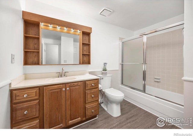 8423 Everett Way Unit A, Arvada, CO 80005 - bathroom featuring toilet, vanity, wood finished floors, and bath / shower combo with glass door