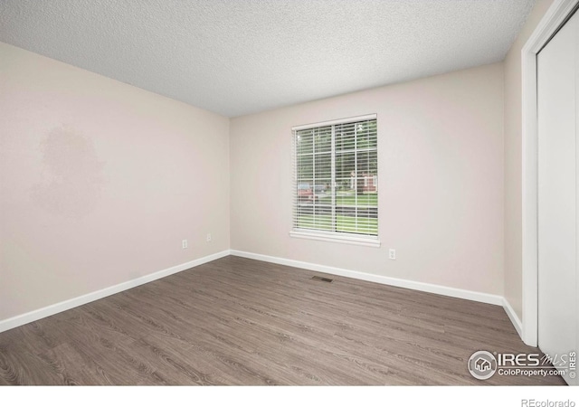 8423 Everett Way Unit A, Arvada, CO 80005 - empty room featuring wood finished floors, baseboards, and a textured ceiling