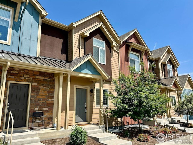 1240 Wren Ct Unit D, Longmont, CO 80501 - view of property with a standing seam roof, stone siding, and metal roof